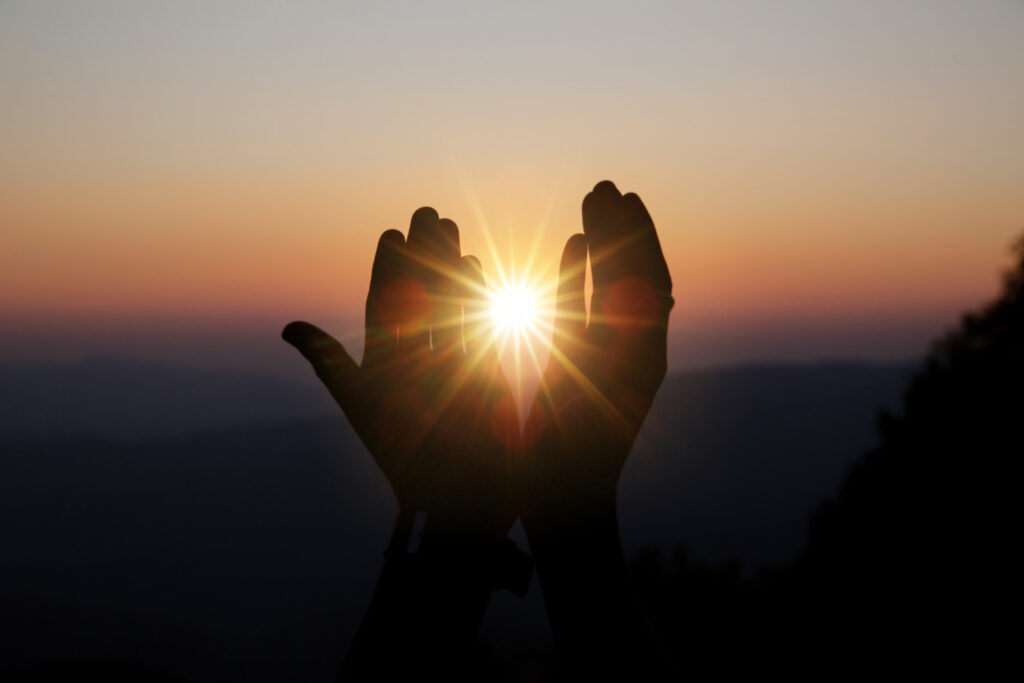 spiritual prayer hands sun shine with blurred beautiful sunset (1)